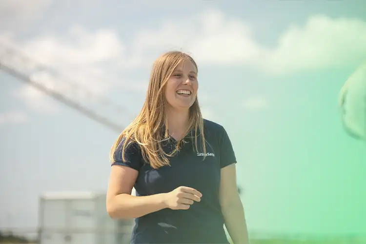 About Us – Skysails employees in nature in front of a Skysails system.