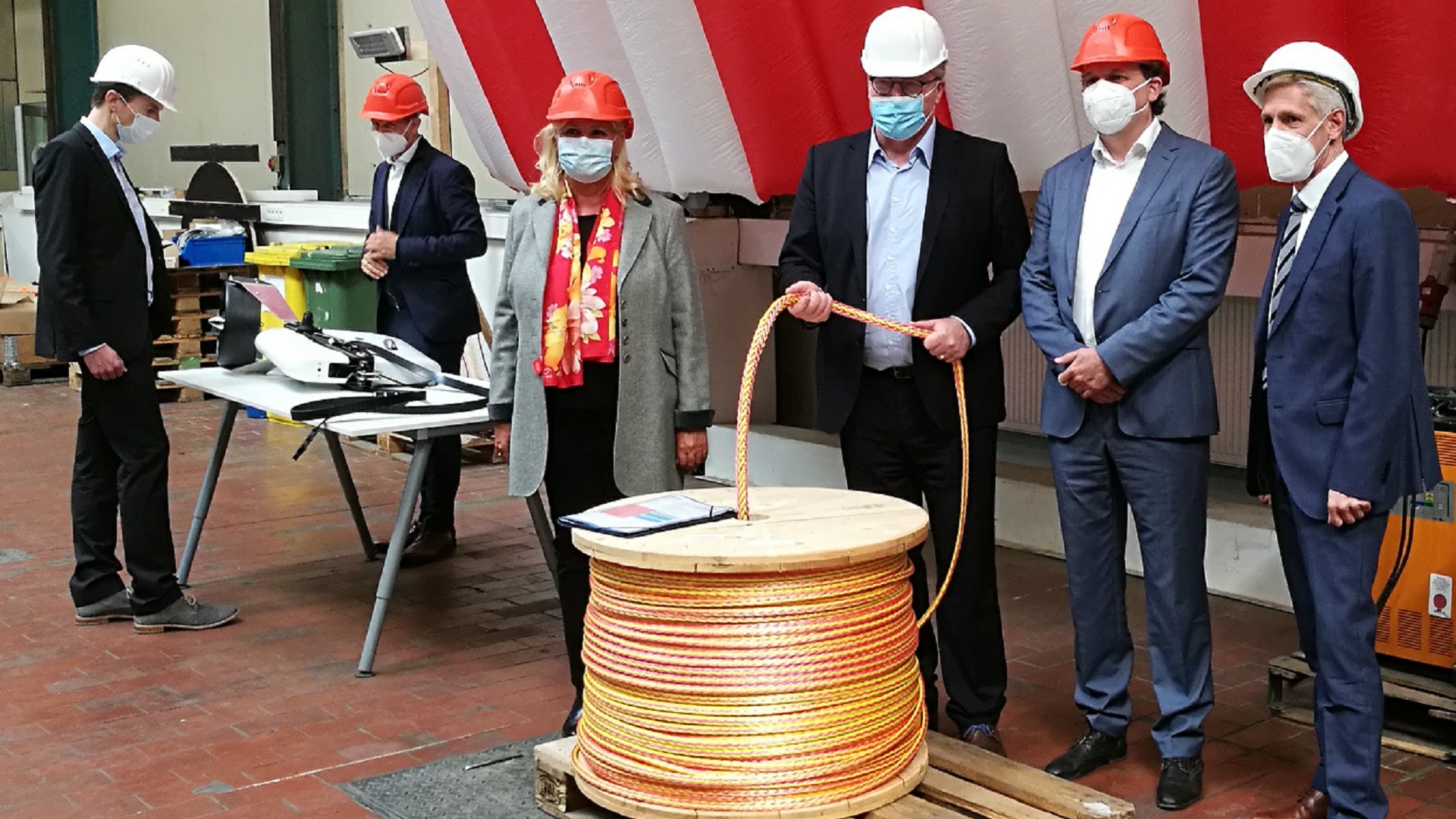 News Blog – Stephan Wrage (CEO of Skysails), Dr. Bernd Althusmann (Member of the Lower Saxony State Parliament), and Skysails employees in a Skysails hall.