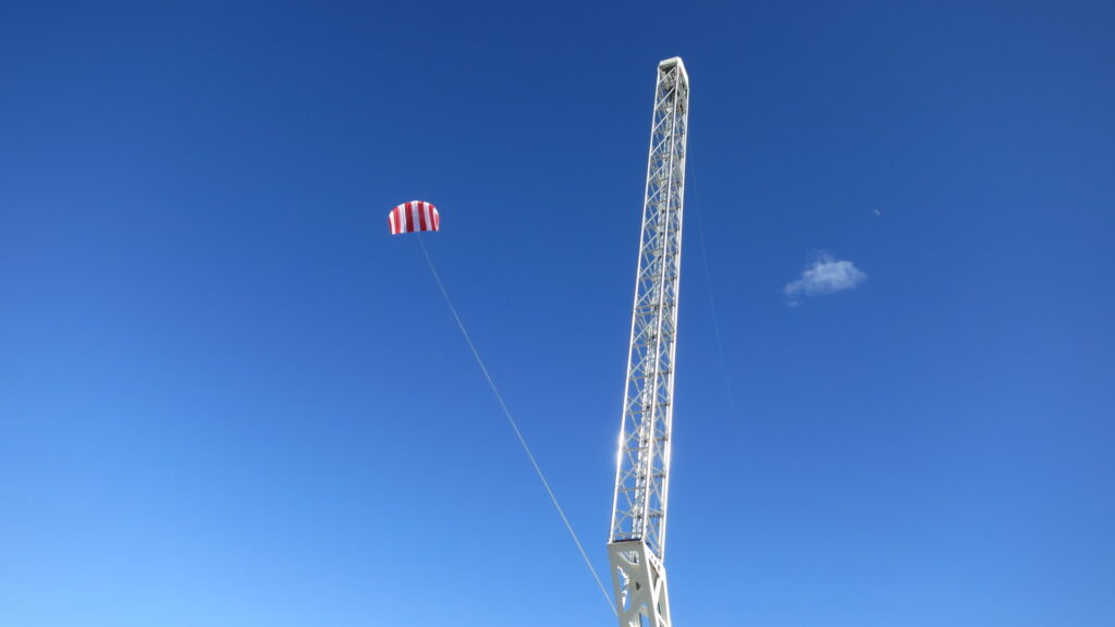 News Blog – a Skysails kite against a blue sky with its launch and landing mast.