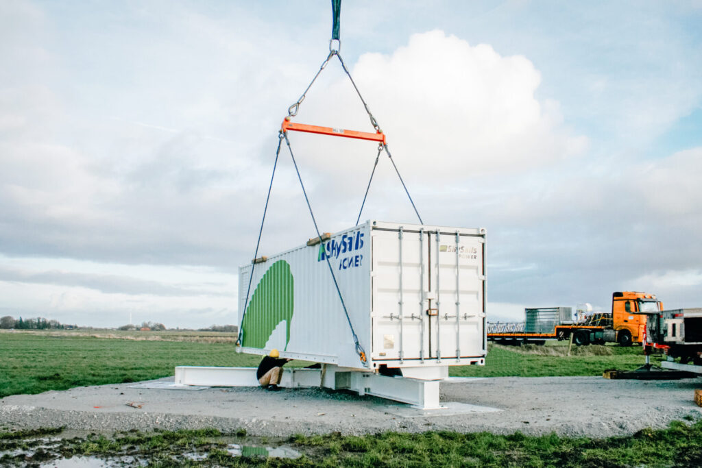 Ground station of airborne wind energy system being lowered on to tripod with a crane.